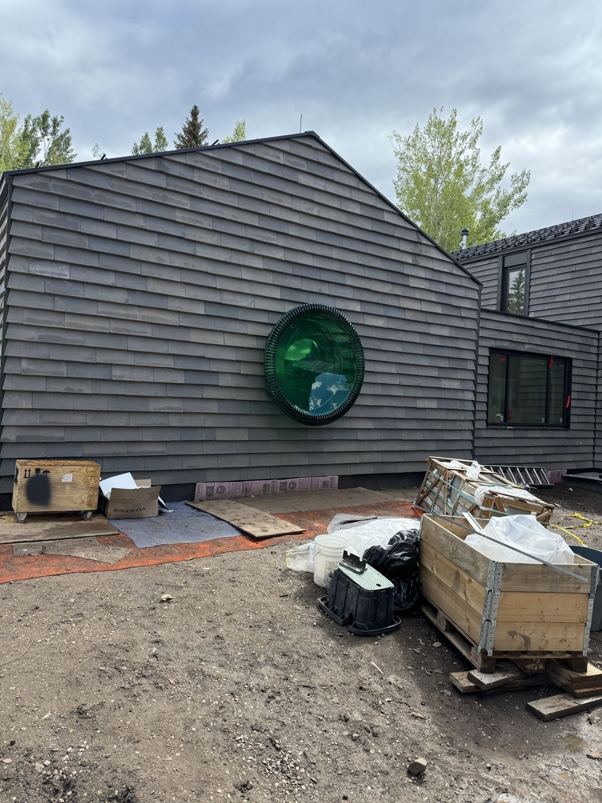 Feature wall with slate shingle siding and round glass window