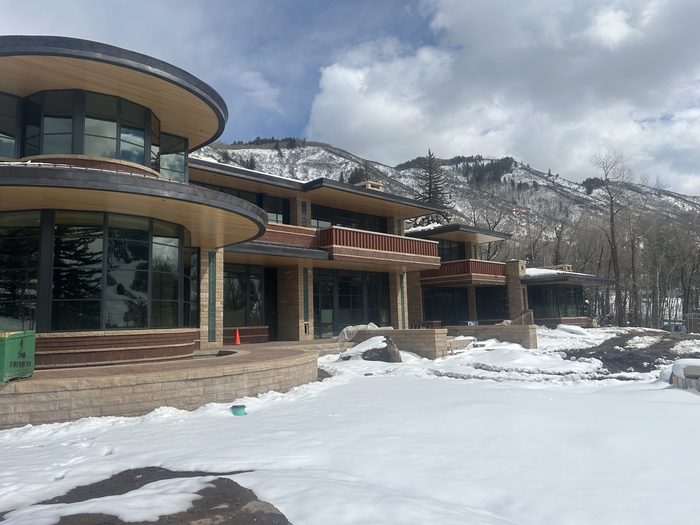 Finished exterior — the baluster system reads across the tiered, curved-glass balconies.