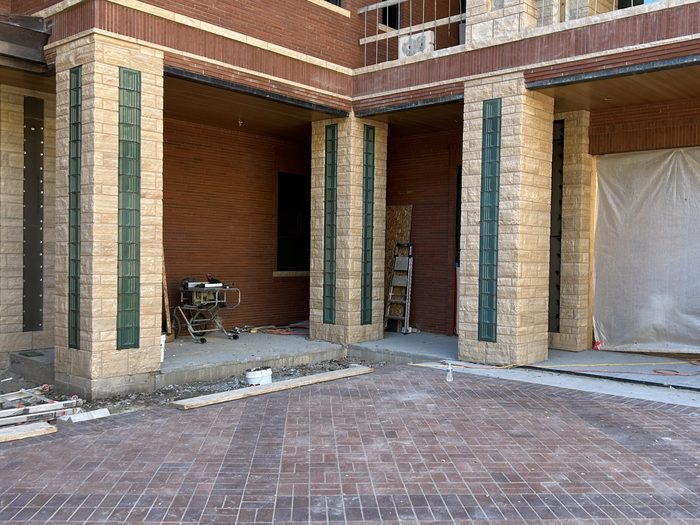 Exterior corner with several stone pillars, each receiving a green terracotta inlay.