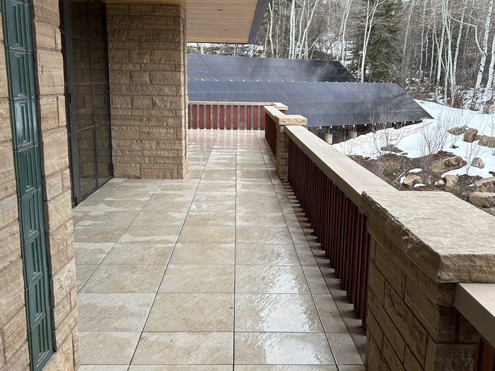 Finished balcony — the green terracotta inlay runs as a vertical strip in the stone wall.