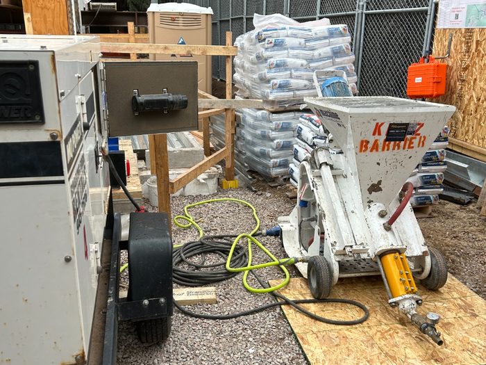 Pump and pallets of self-leveler staged in the side yard next to the generator.