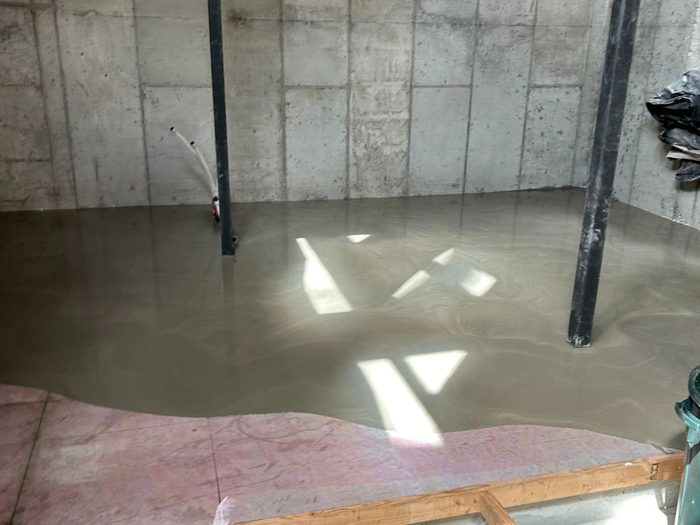 Material flowing out flat and settling to a smooth, consistent plane.
