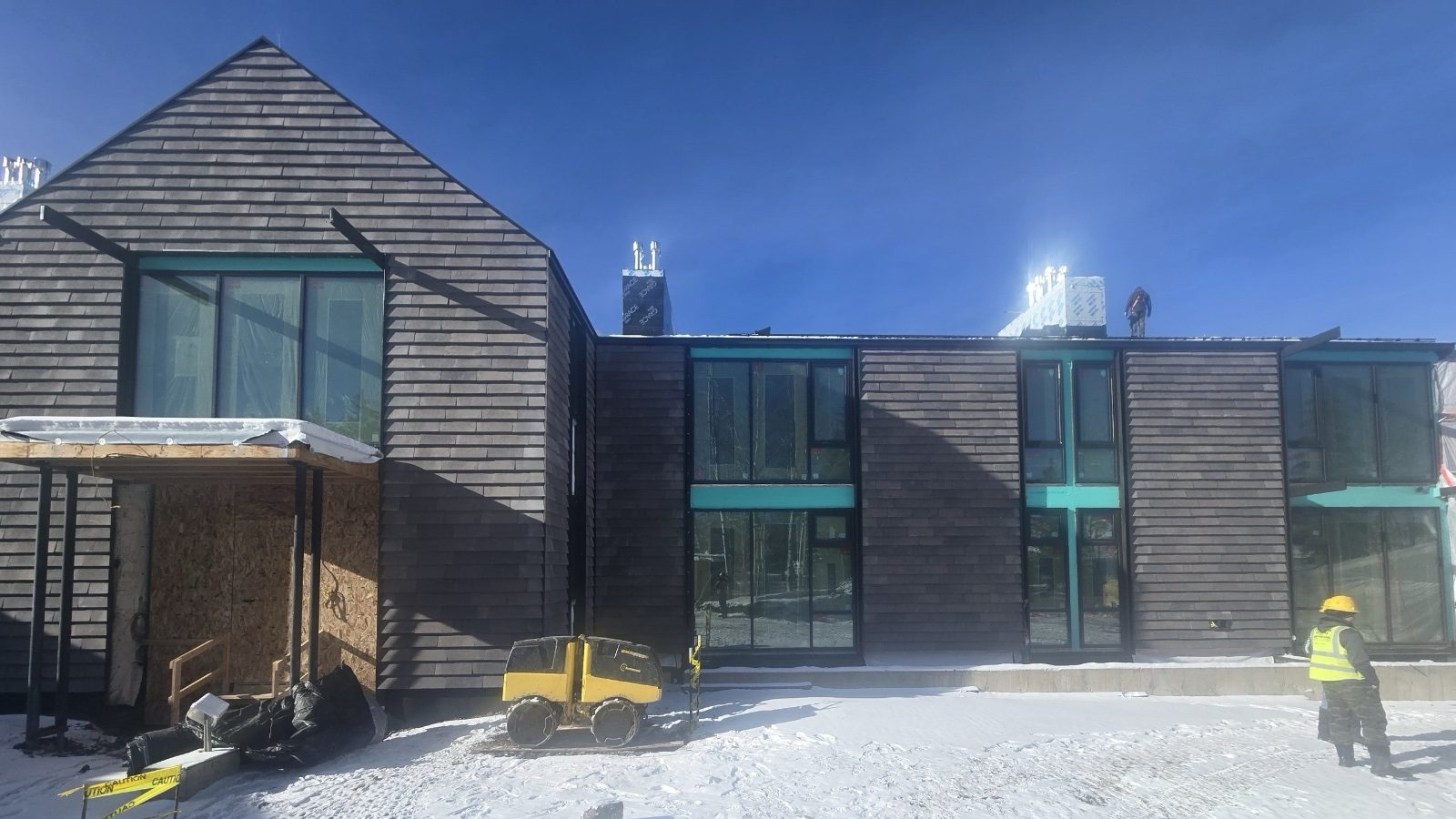Near-complete rainscreen elevation on the Aspen residence — large-format grey cladding panels wrapping the facade