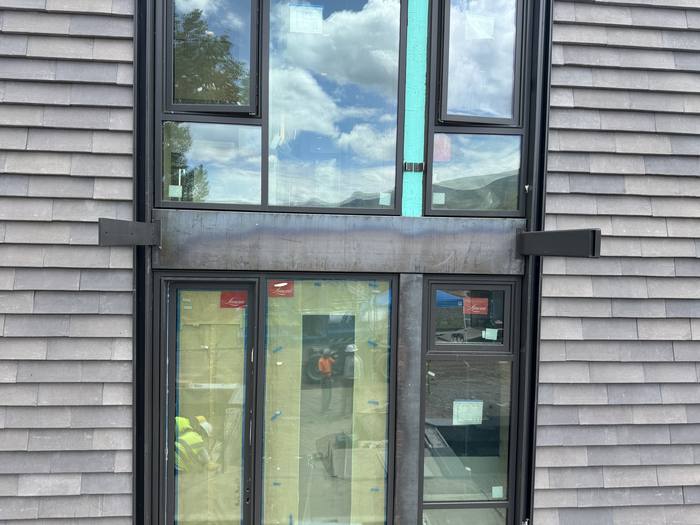 Vertical steel mullions installed on the clad exterior wall.