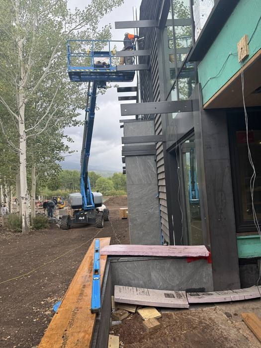 Jobsite courtyard with a boom lift and upper-level steel beams.