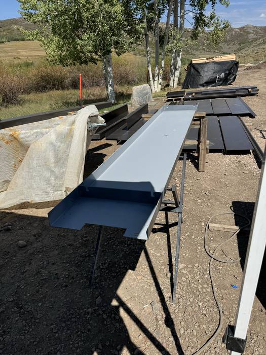 Raw steel channel component on sawhorses, ready to set.