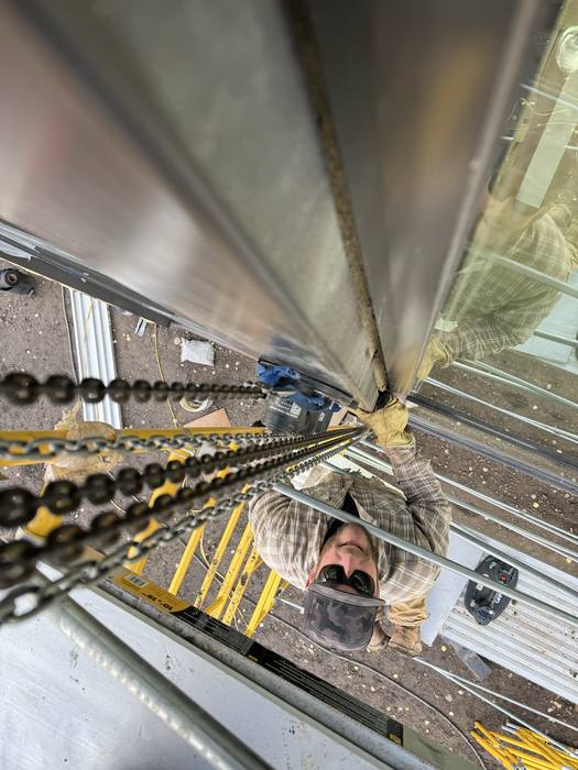 Looking down a vertical steel column during installation.
