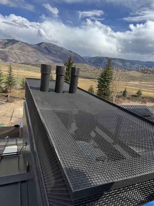 Rooftop — black metal grating and custom steel chimney stacks.