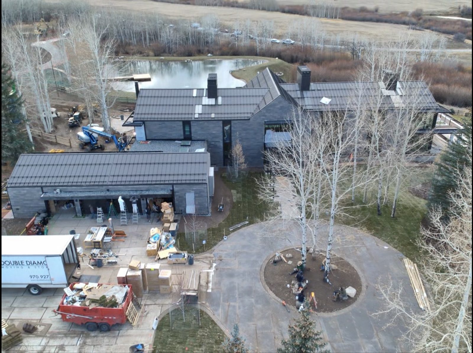 Elevated view of the Aspen residence near completion — dark metal roof and siding with expansive glass