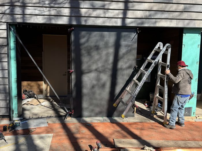 Black metal substrate set into the wall opening before the slatted panels go in.