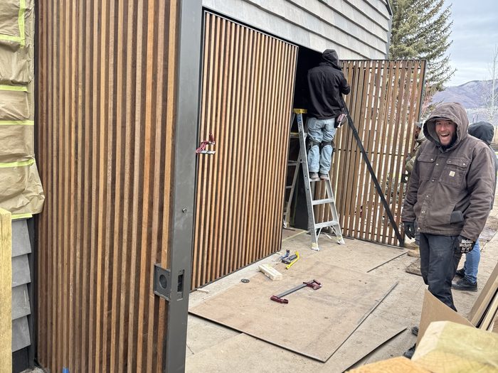 Panel swung open like a gate, top hinge and track fine-tuned from a ladder.