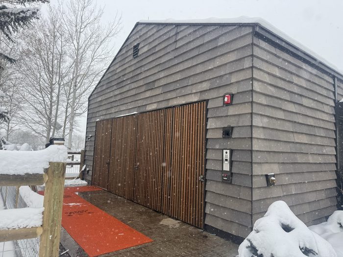 Three panels closed — the slat wall reads as a single architectural feature.