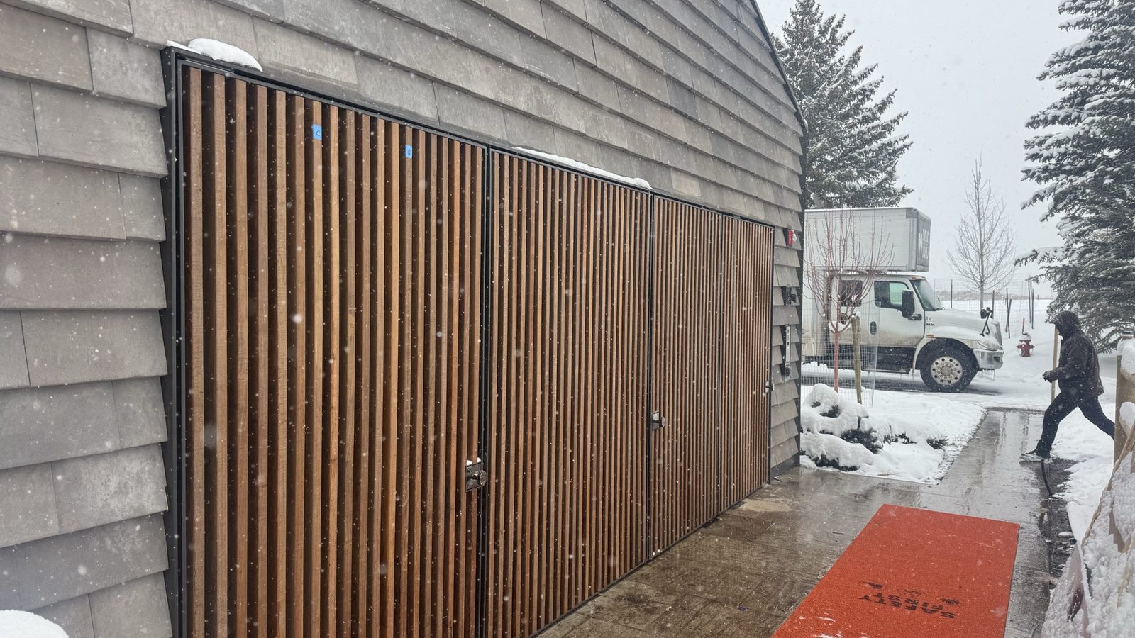 Finished slat wall on the Aspen residence — three vertical wood-slat panels set in black steel frames