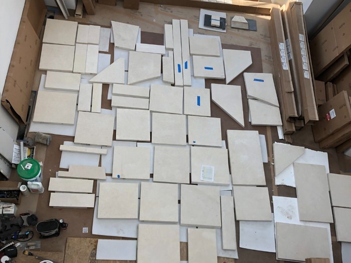 Every piece of the surround dry-laid on the floor and marked before a single stone went up.