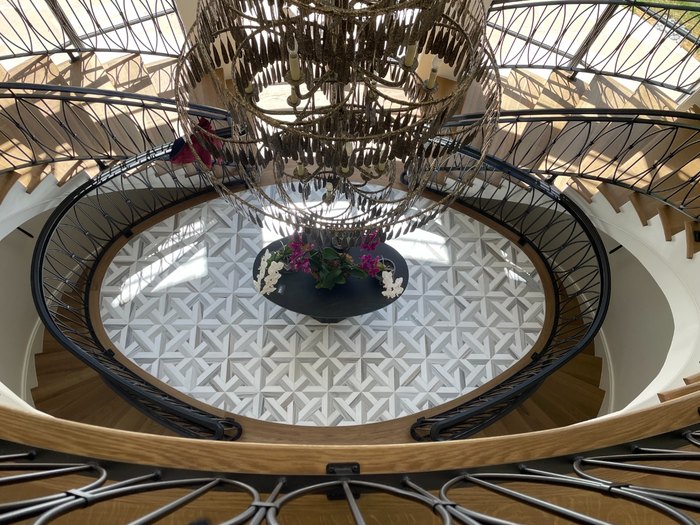 Marble pinwheel mosaic in the stair hall, seen down through the oval opening.