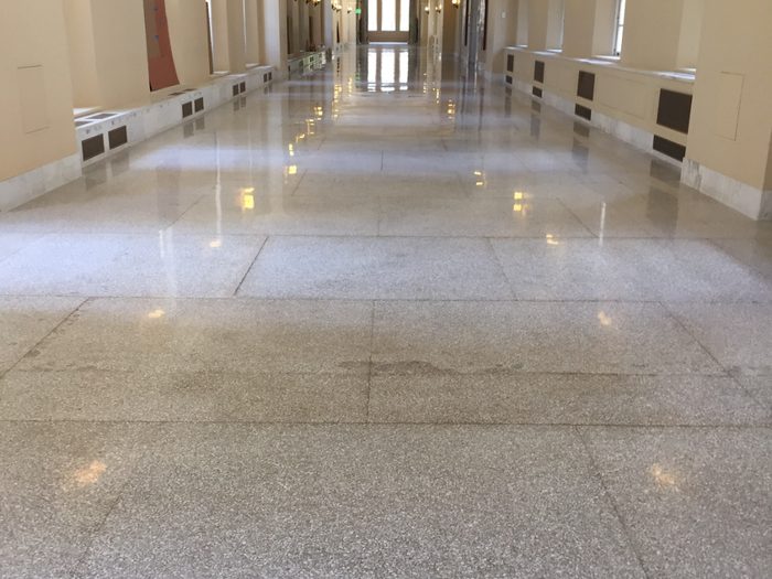 Finished corridor — polished terrazzo reflecting daylight from the windows.