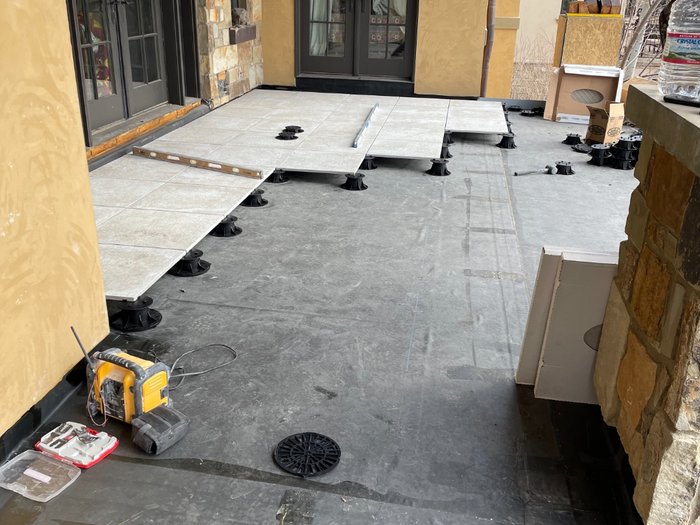 Pedestals set out across the waterproofed deck with the first pavers running out from the doors.