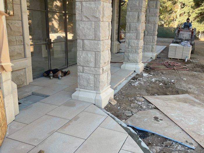 Courtyard walkway with a trench drain set flush at the transition.